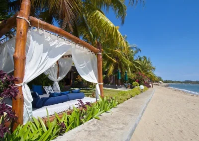 Vue de la plage sur le lit baldaquin de la villa à Nosy Be