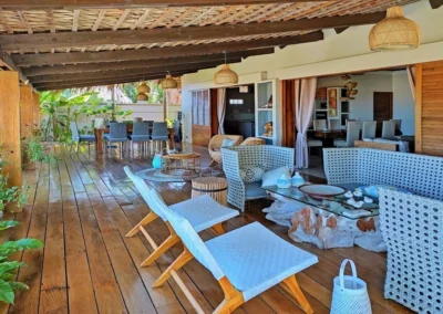 Grande varangue extérieure avec salon et vue sur le jardin de la villa Sakina