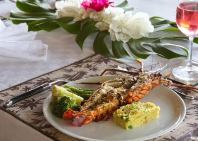 Assiette gastronomique avec langouste servie à table dans la villa Sakina, location luxe à Nosy Be.