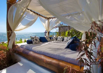 Canapé lit en baldaquin avec voiles blancs et vue sur la mer à Villa Sakina