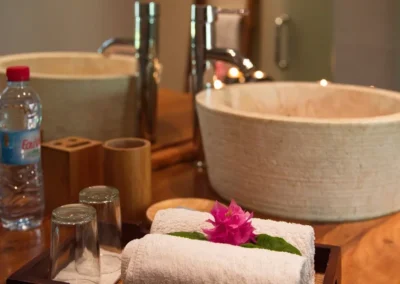 Fleur tropicale posée sur une serviette, détail élégant dans la salle de bain de la villa à louer à Nosy Be.